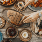 A woman is slicing bread on a table