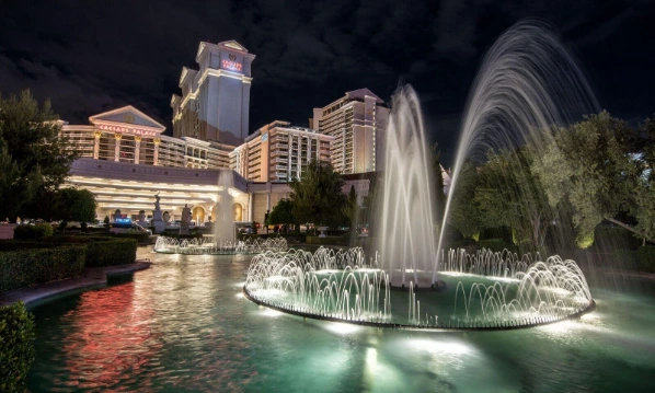 A nighttime photo of The Fountains in front of Caesars Palace Las Vegas