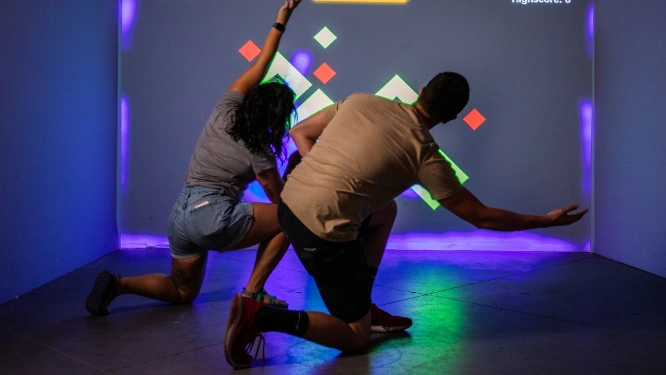 A man and woman play an interactive movement game at Electric Playhouse in Las Vegas at Caesars Forum Shops