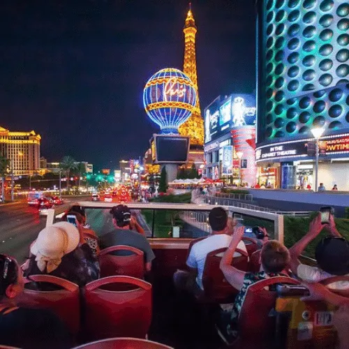 People ride on the open top level of the Big Bus Las Vegas Tour