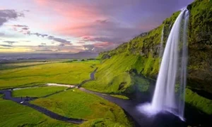 A view of a tall waterfall and the sunset on the Legendary Iceland FlyOver Las Vegas ride